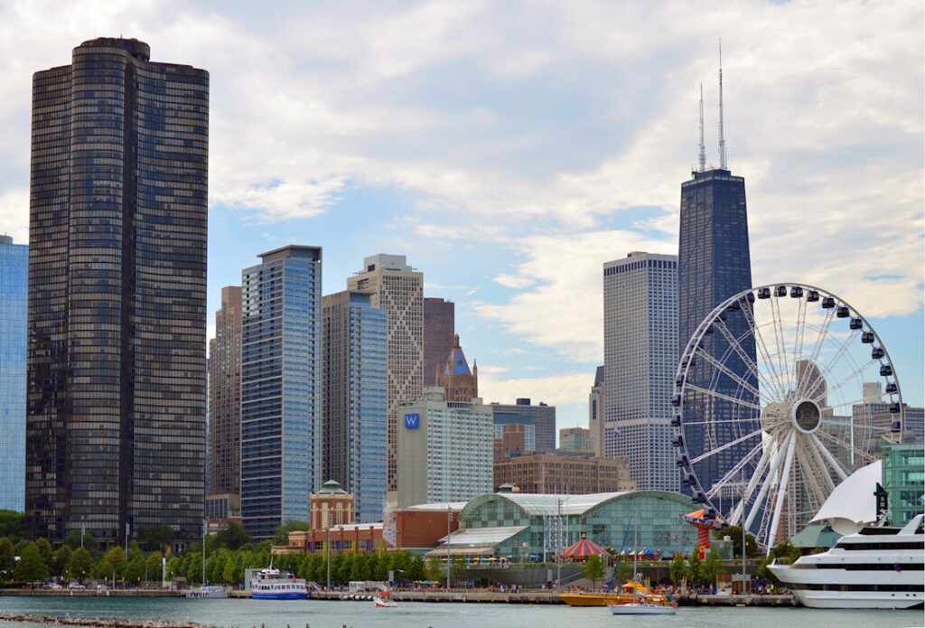 Summer vacation in Chicago, Illinois, featuring a bustling Navy Pier with families enjoying various attractions and rides against a backdrop of the city skyline on a sunny day.