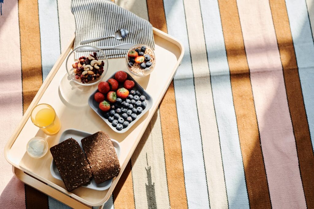 Image showing a balanced and nutritious breakfast spread. The table is set with bowls of oatmeal topped with fresh berries, a plate of scrambled eggs beside slices of whole-grain toast, a small bowl of mixed nuts and seeds, and a glass of freshly squeezed orange juice. The background subtly emphasizes a bright, healthy morning setting to inspire a positive start to the day, reflecting the theme that healthy food is good for breakfast