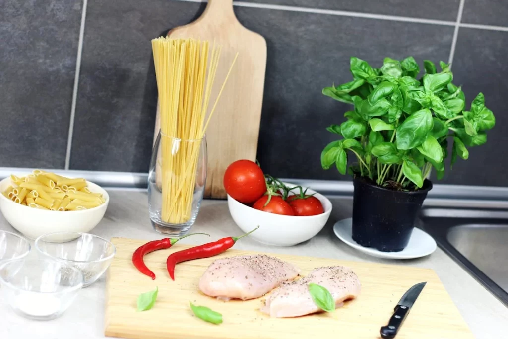 A bowl of steaming ramen noodles being prepared with seasoning added, creating a savory broth and enhancing the dish with rich flavors.