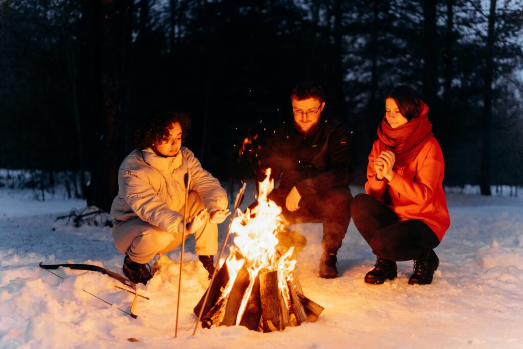 "Cozy winter vacation scene with snow-covered mountains, a log cabin, and warm winter clothing. Perfect essentials for a winter vacation include waterproof boots, insulated jackets, and emergency gear for a safe and enjoyable trip in the cold weather."