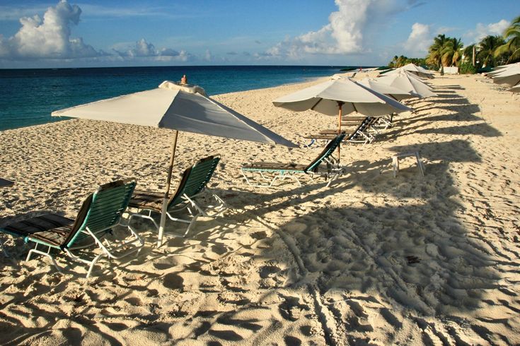 View of Anguilla’s pristine white sandy beach, gently caressed by crystal-clear waters under a serene blue sky, capturing the quiet elegance of the Caribbean Islands."
This text maintains a natural flow while highlighting the beauty of the Caribbean Islands