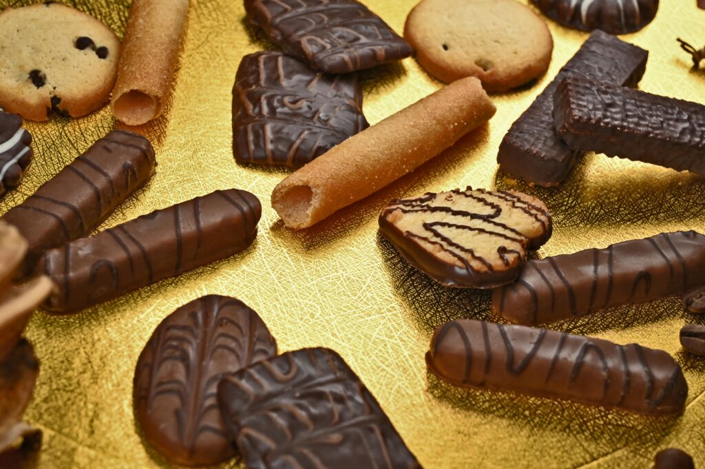 Freshly baked chocolate chip cookies on a rustic wooden surface, showcasing a gooey chocolate center and golden-brown edges, garnished with a sprinkle of sea salt.