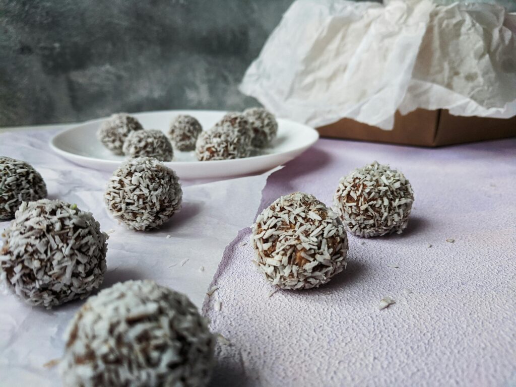 Delicious chocolate chip cookies topped with golden coconut flakes, showcasing a crispy exterior and a soft, chewy center, surrounded by scattered chocolate chips