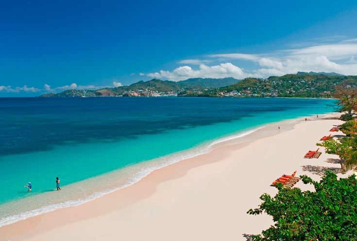 "A serene view of Grenada's lush green landscapes and pristine beaches, capturing the natural beauty of the Caribbean Islands. Palm trees sway in the gentle breeze, overlooking crystal-clear turquoise waters, showcasing the tranquility and charm of the Caribbean Islands."