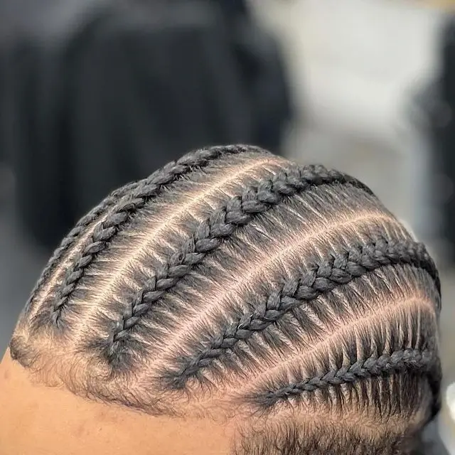 Close-up of a man with neatly styled cornrows, showcasing a classic and timeless look. Cornrows are a popular choice for Braids for Men, offering both style and protection.