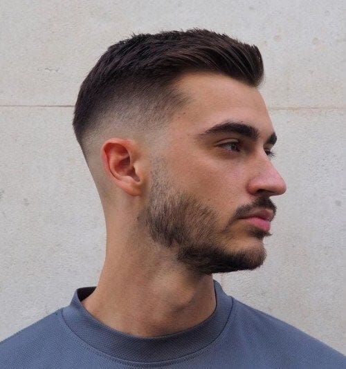 Close-up of a man with a sleek Taper Fade haircut, showcasing the clean and subtle lines of the style. The Taper Fade is a popular choice in hairstyles for men, blending seamlessly for a polished look.