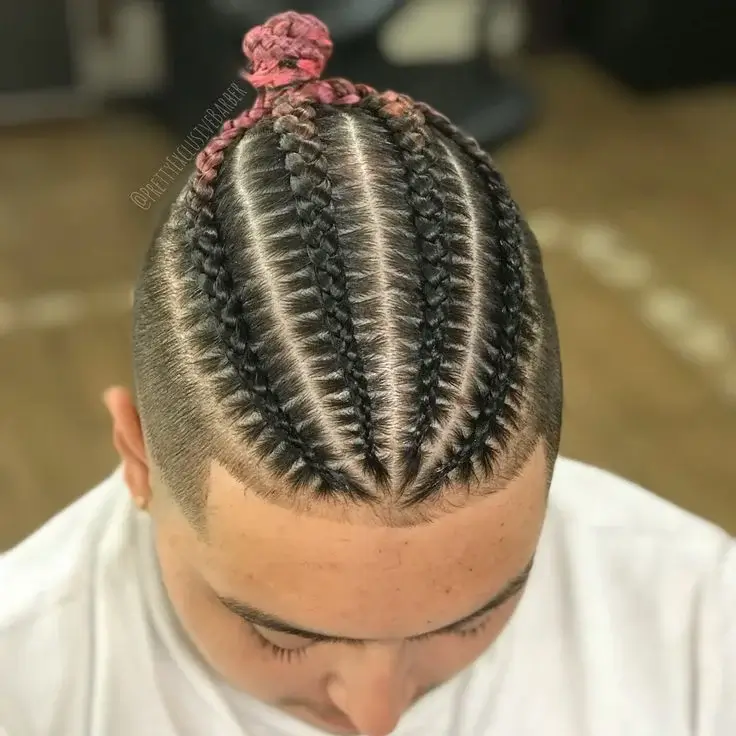 A man with long hair styled in rugged Viking Braids for Men, featuring a single thick braid down the back with shaved sides, giving a bold, masculine look.